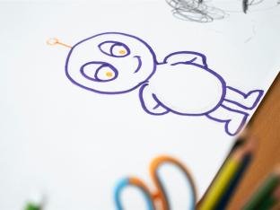 Bunte Zeichentrickfigur-Skizze auf Papier mit Buntstiften an der Seite.